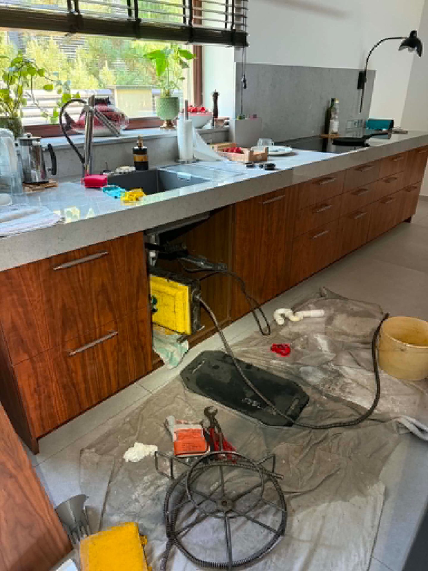 Kitchen drain pipe cleaning — clog removal in progress